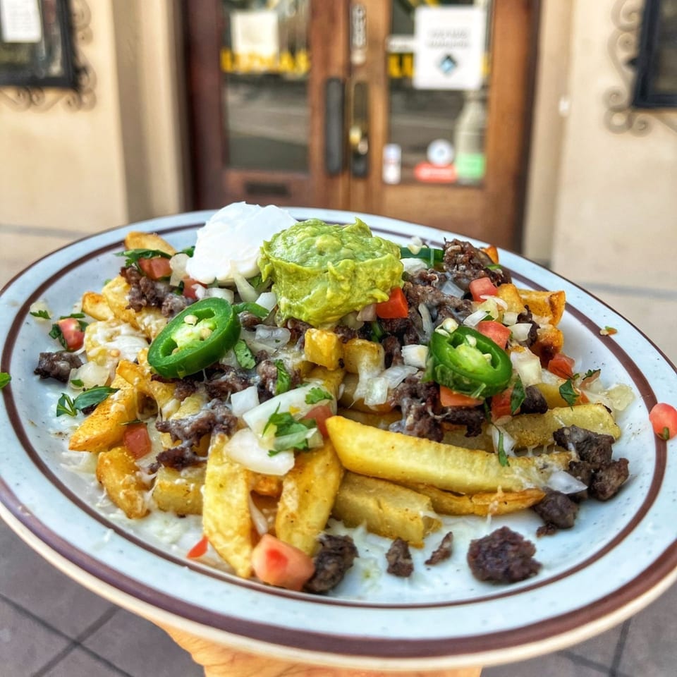 Loaded carne asada fries with guacamole, sour cream, jalapeños, and pico de gallo from Lunas Bar and Grill.