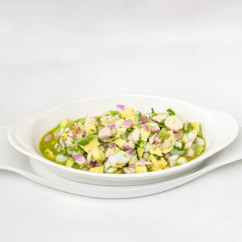 Lunas Bar and Grill's Mexican ceviche with shrimp, avocado, red onion, and cilantro in a white bowl.